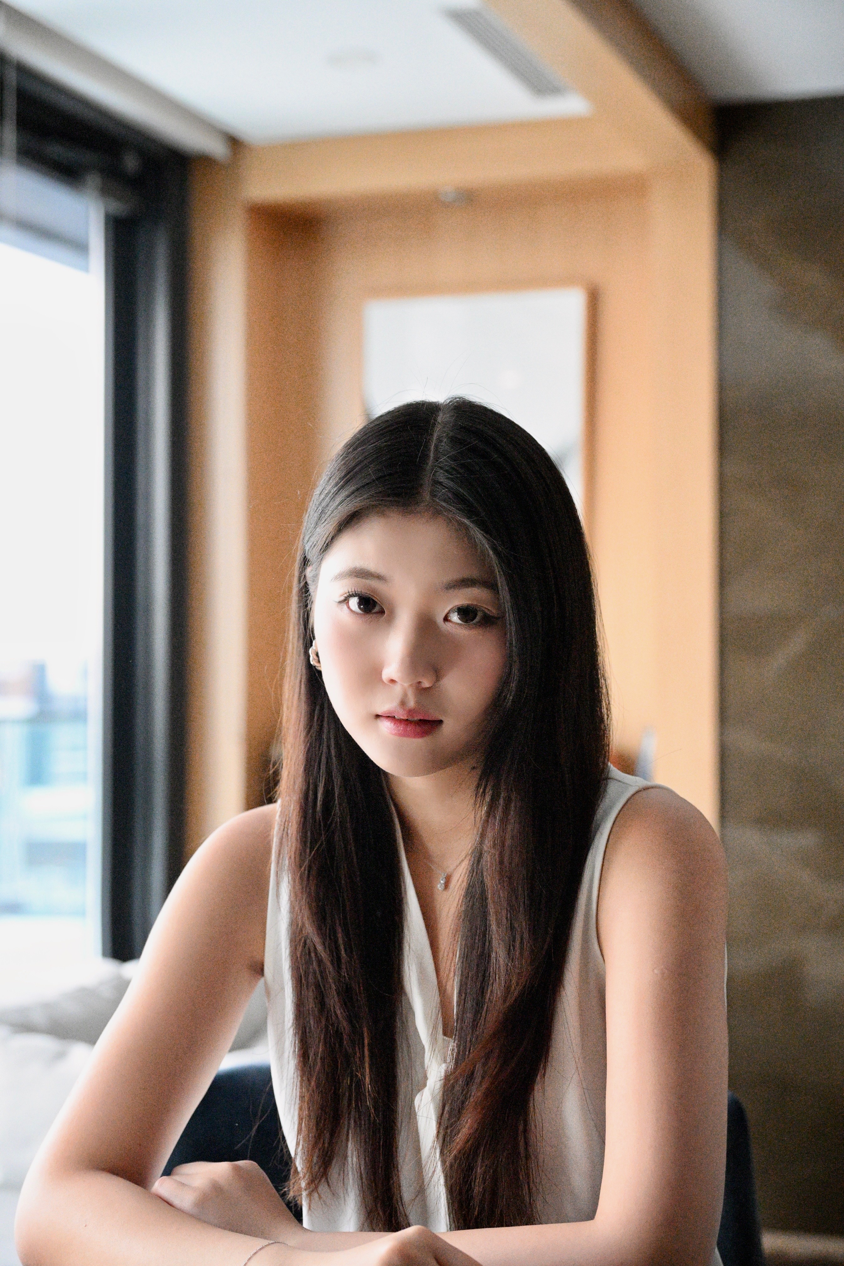Professional headshot of a woman with long dark hair in a white top